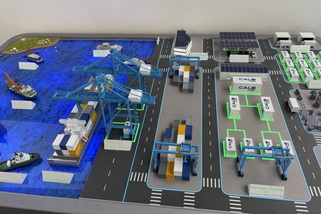 Scale model of an automated container terminal with quay cranes, berths and electrified yard equipment, shown at the Advanced Maritime Technology Expo in Amsterdam
