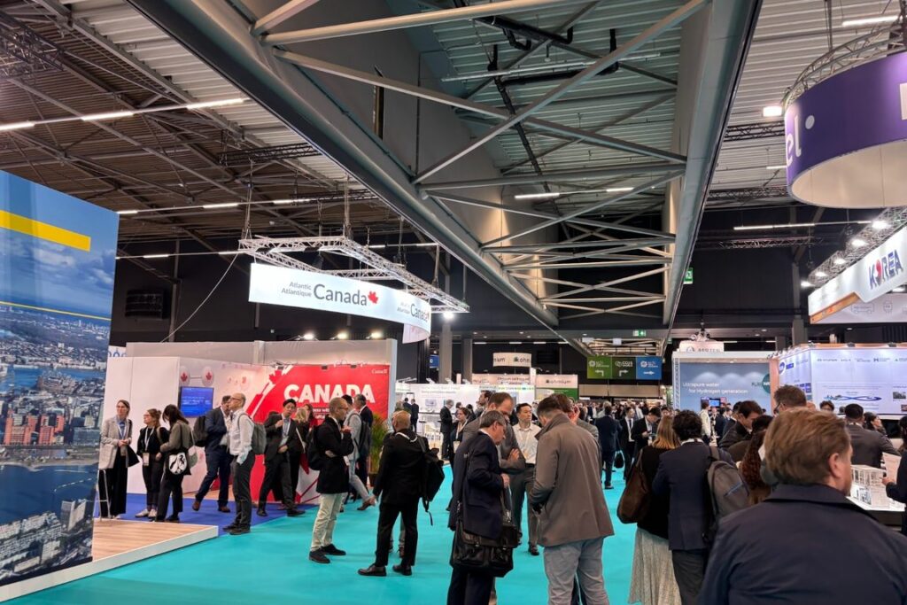 Exhibition floor at the World Hydrogen Summit and Exhibition in Rotterdam Ahoy, with national pavilions and visitors between stands